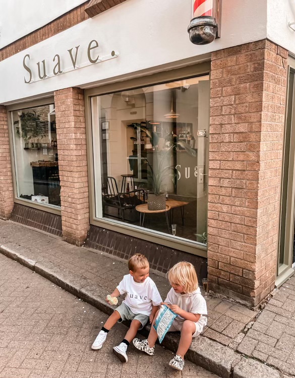Two little ones in Suave. T-shirts sitting on the kerb outside the shop
