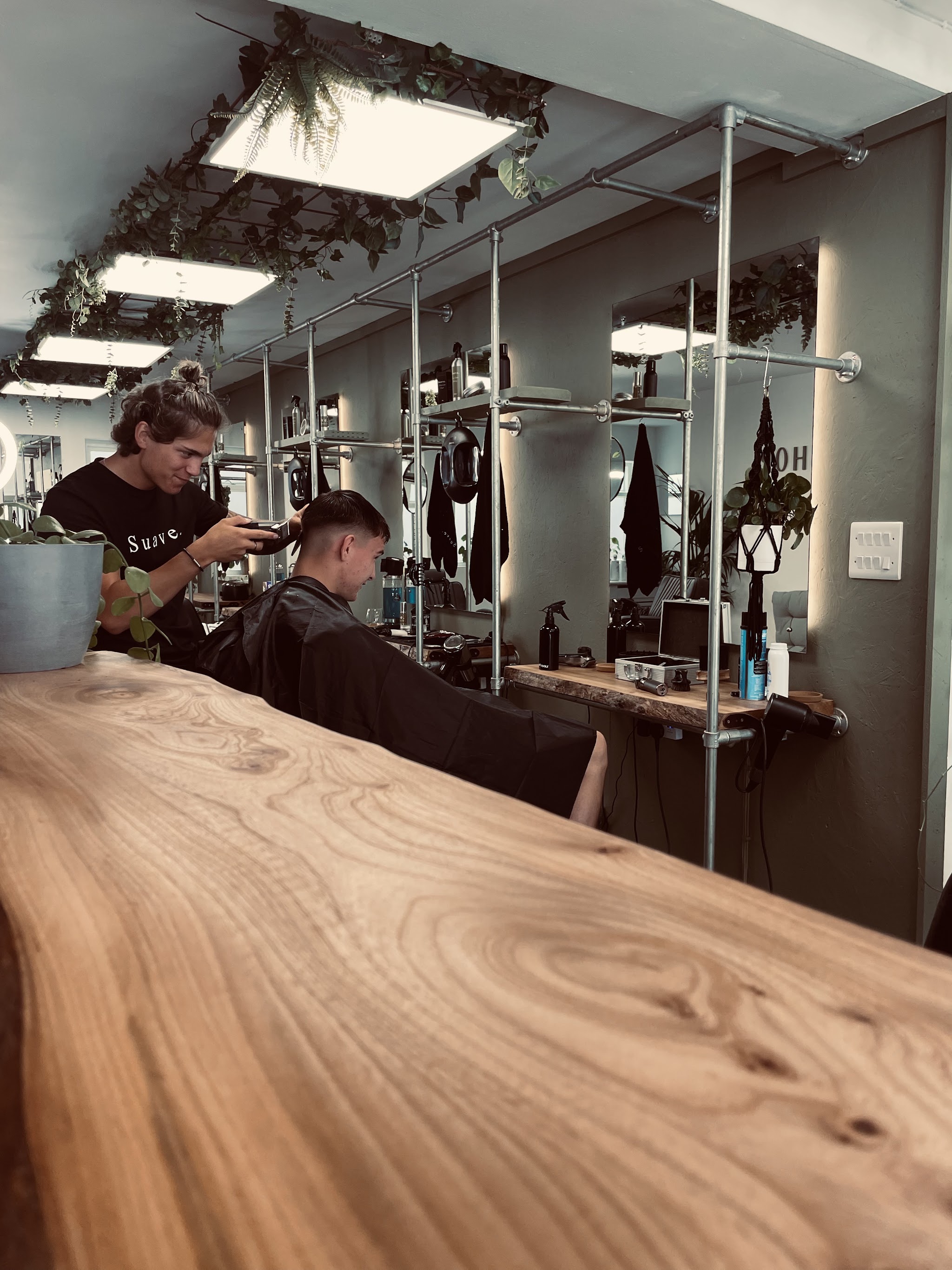Inside Suave.: the long wooden counter and barbers' stations